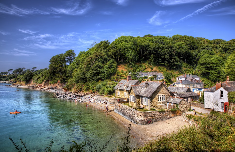 A cottage by the sea in Cornwall, surrounded by trees